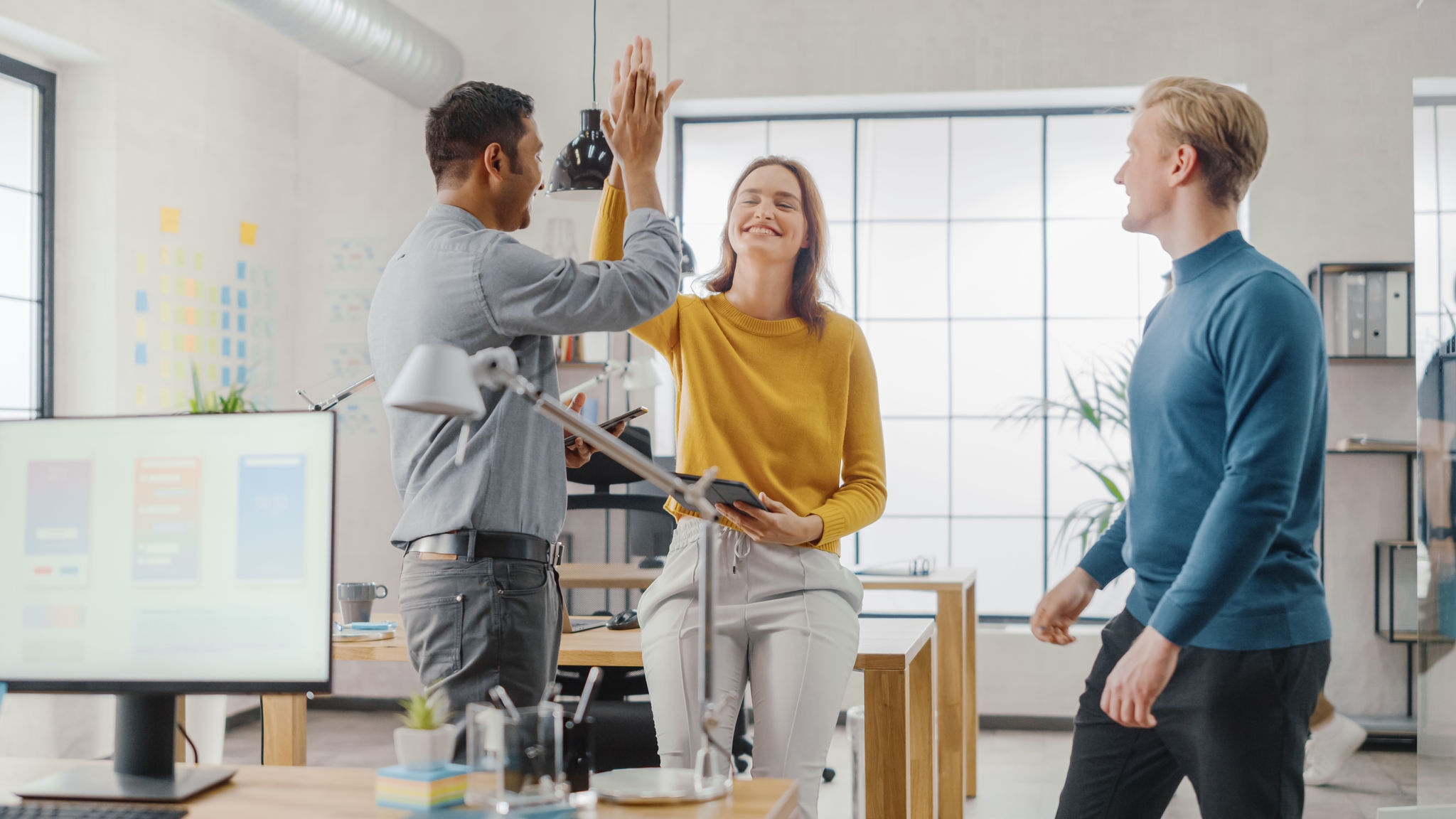 Three Start-up Entrepreneurs Celebrate Success with High Five. They Have Meeting and Discussion about the Project, They Discuss Project Design, Share Touch Screen Digital Tablet and Smartphone Screens