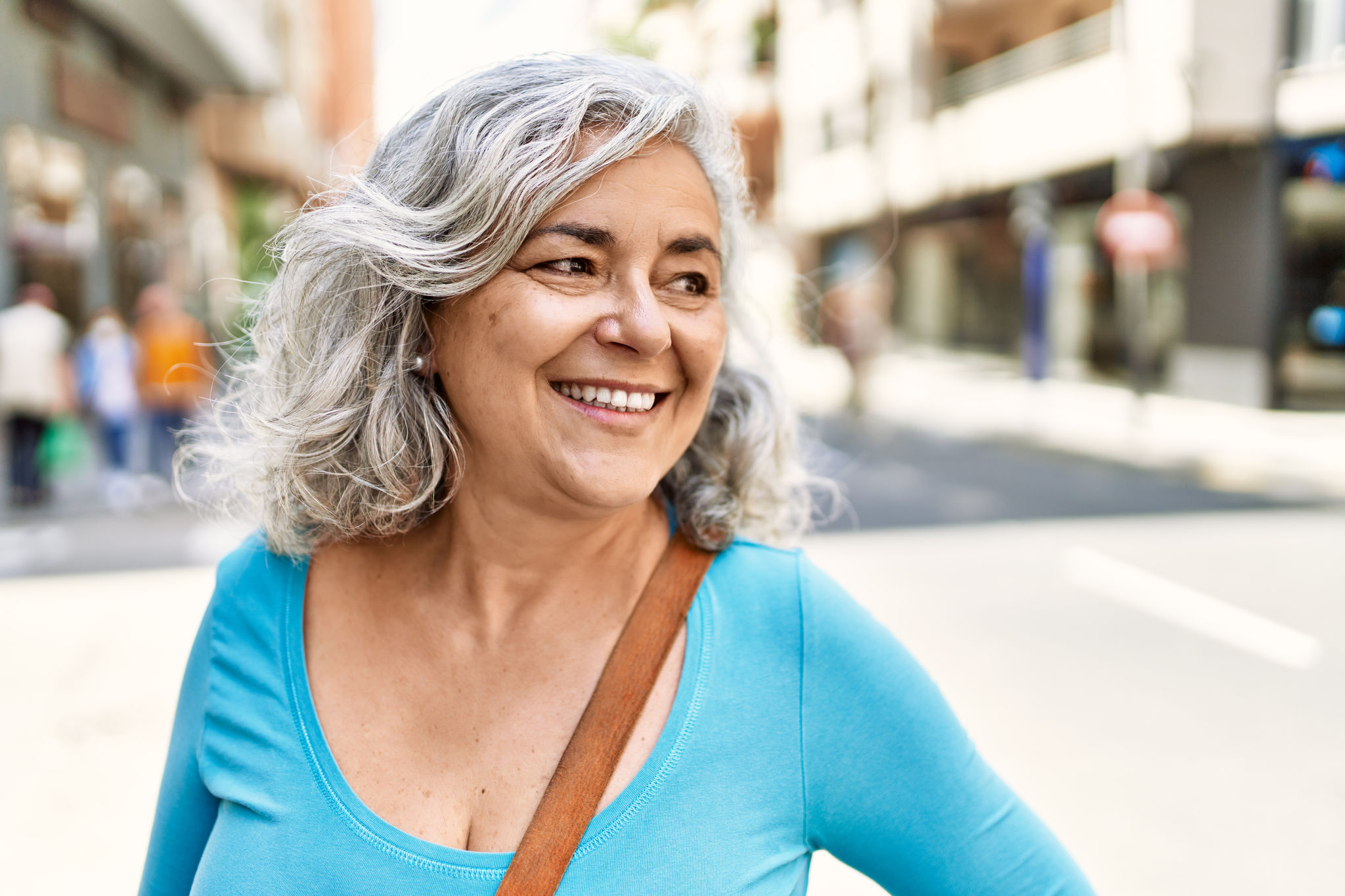 Middle age grey-haired woman smiling happy standing at the city.