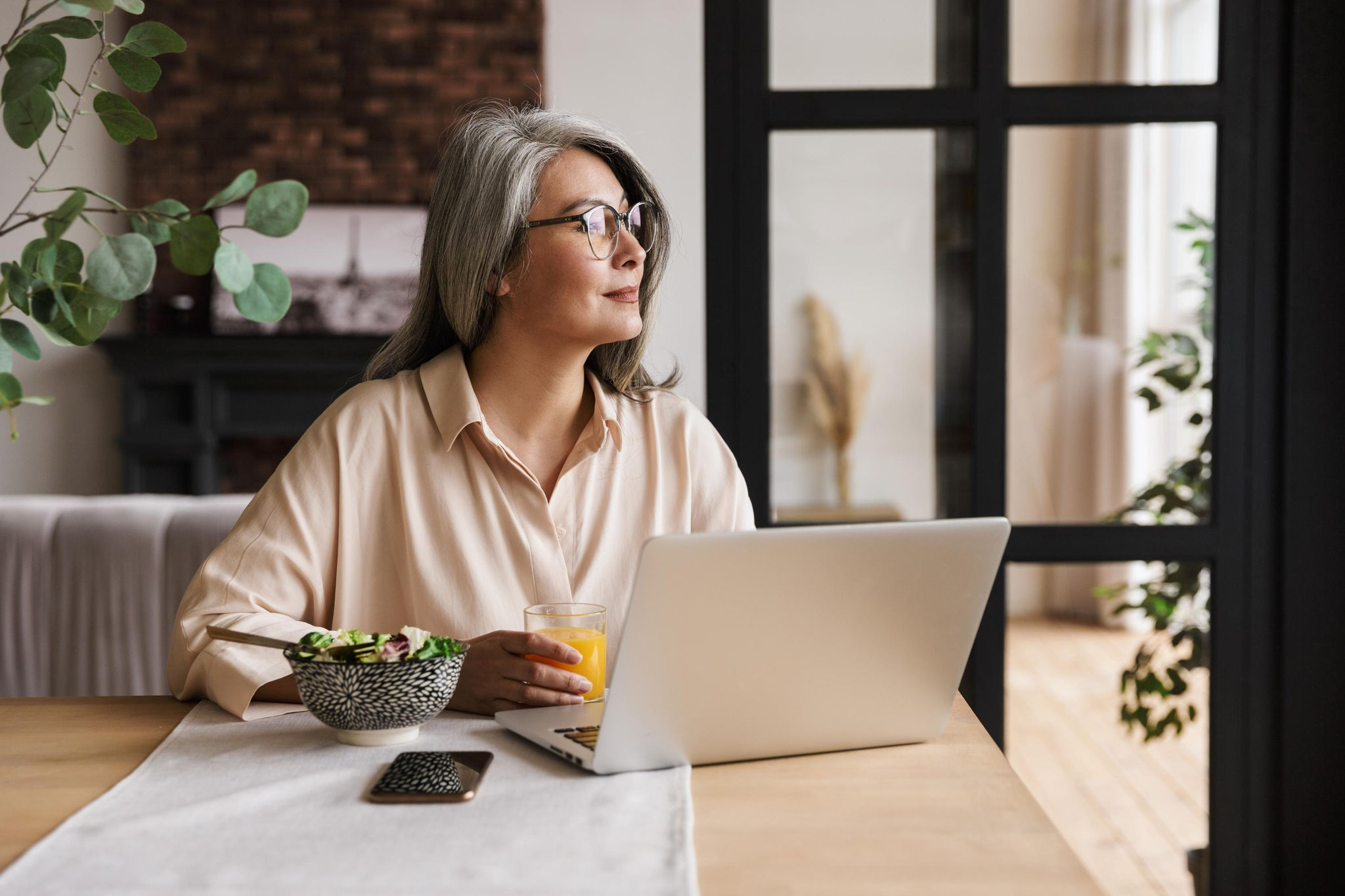 canva-businesswoman-looking-outside-laptop