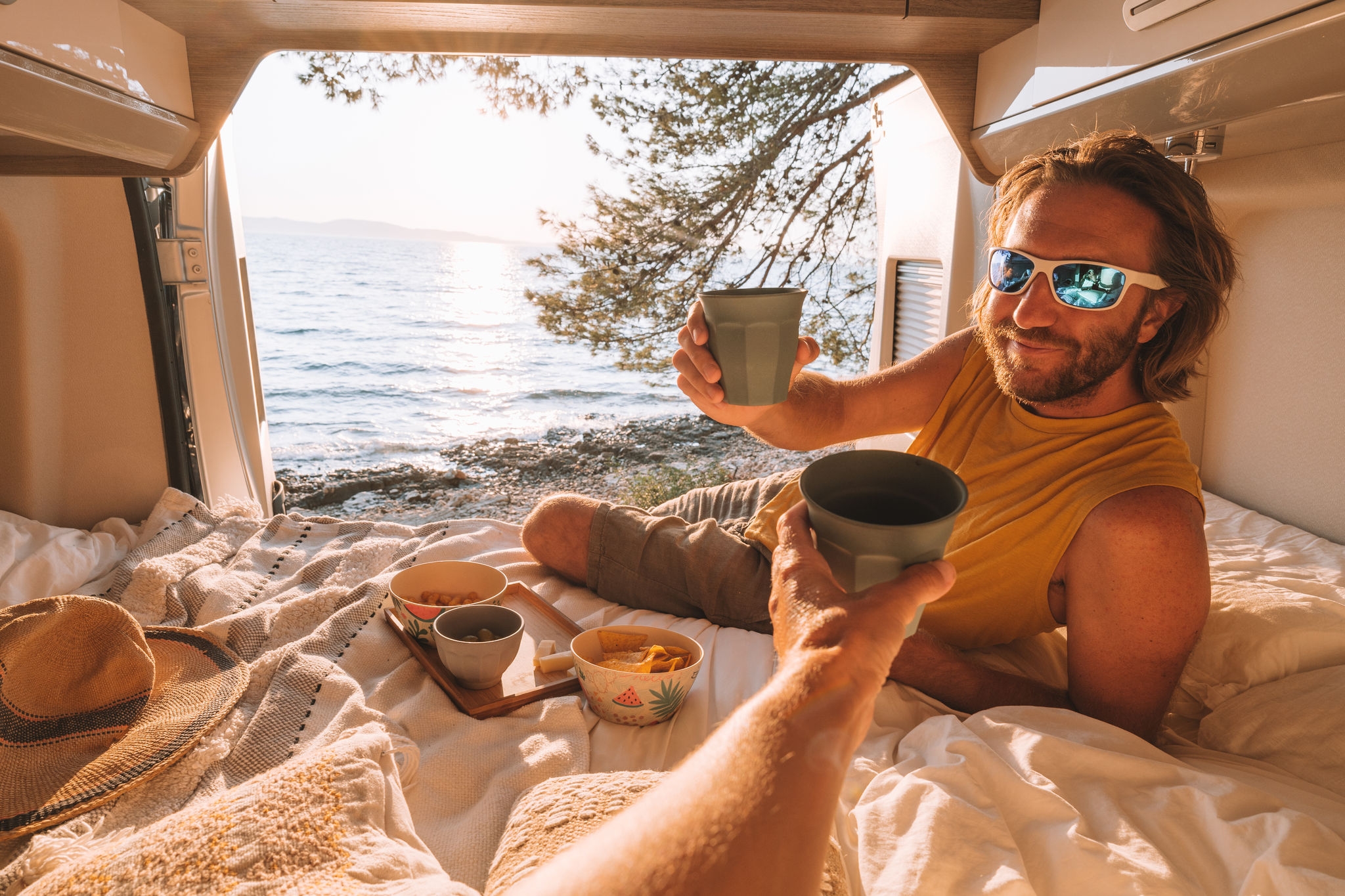 Road trip concept, couple living the van life experience watching stunning view while lying on the bed of the back of a camper