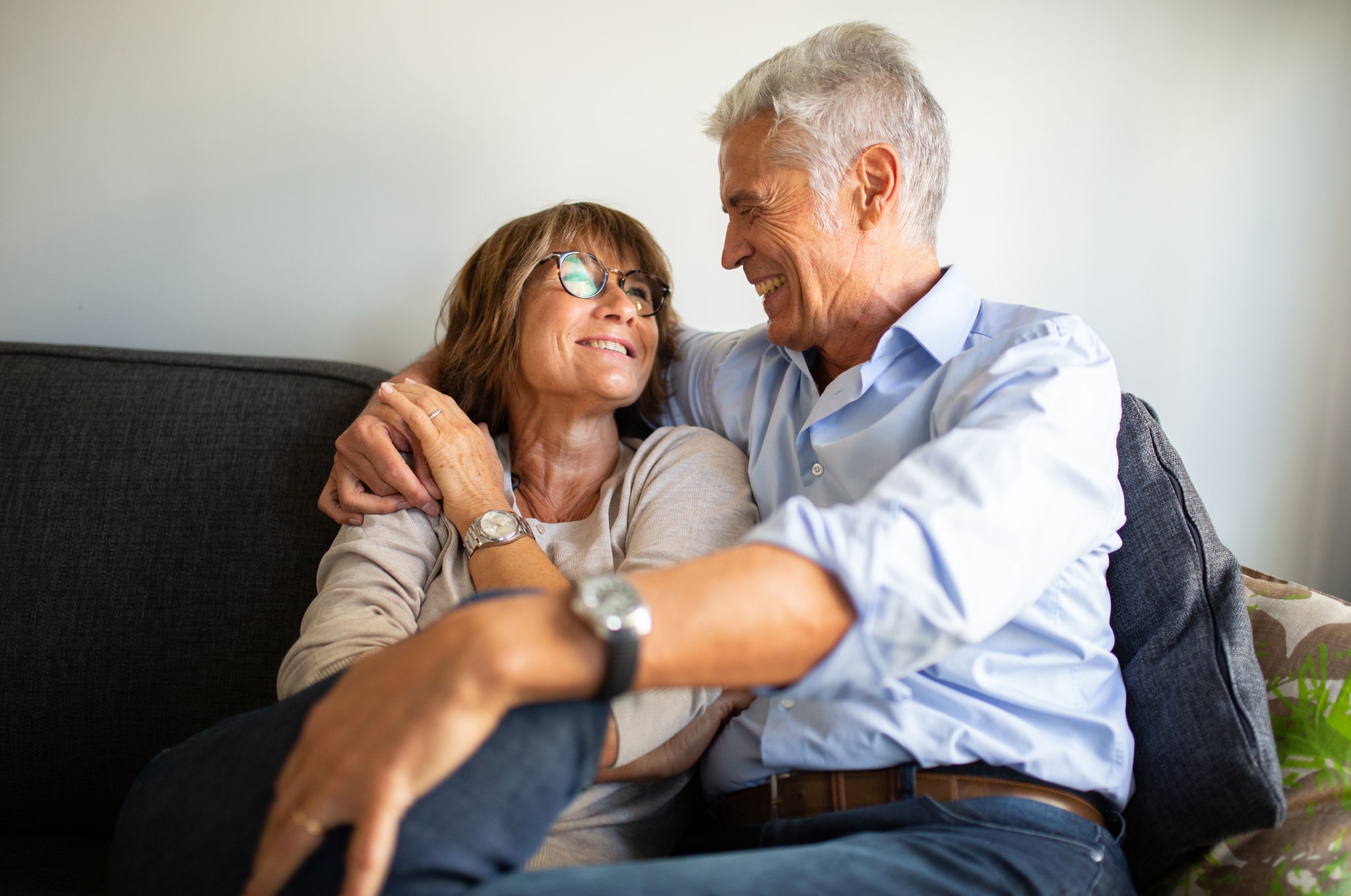 Portrait loving older couple sitting on sofa 