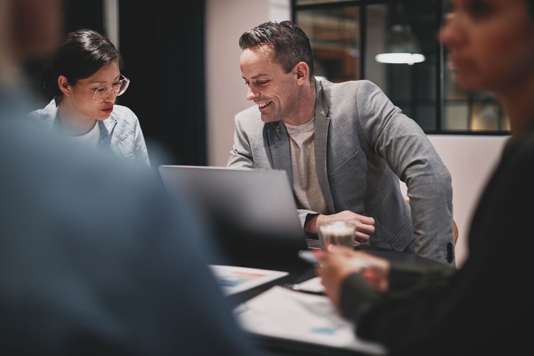 Mature businessman smiling while working with a diverse group of colleagues around a boardroom table